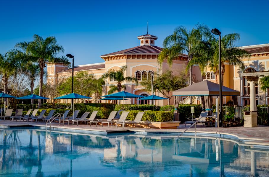 A Mediterranean-inspired rotunda beside palm trees, lounge chairs, and umbrellas, all sitting poolside at Rosen Shingle Creek.