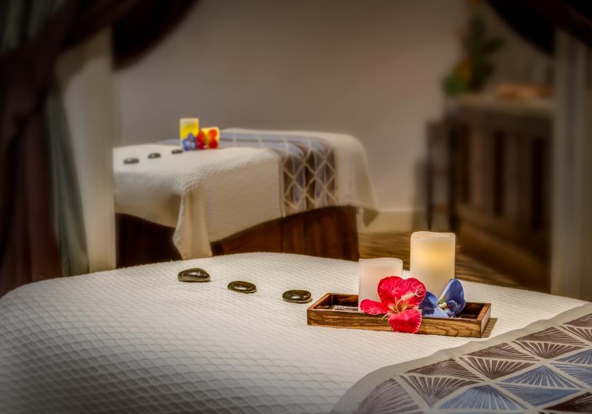 A Perfect Spa Day at Rosen Shingle Creek: What to Expect 4 Two spa beds in a dimly lit room, adorned with candles, flowers, and stones.