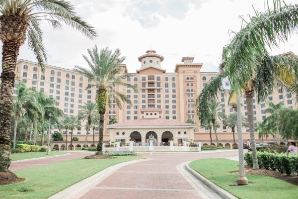 8 Questions to Ask When Choosing a Wedding Venue 10 A winding brick pathway leading to the grand front entrance of Rosen Shingle Creek, flanked by palm trees.