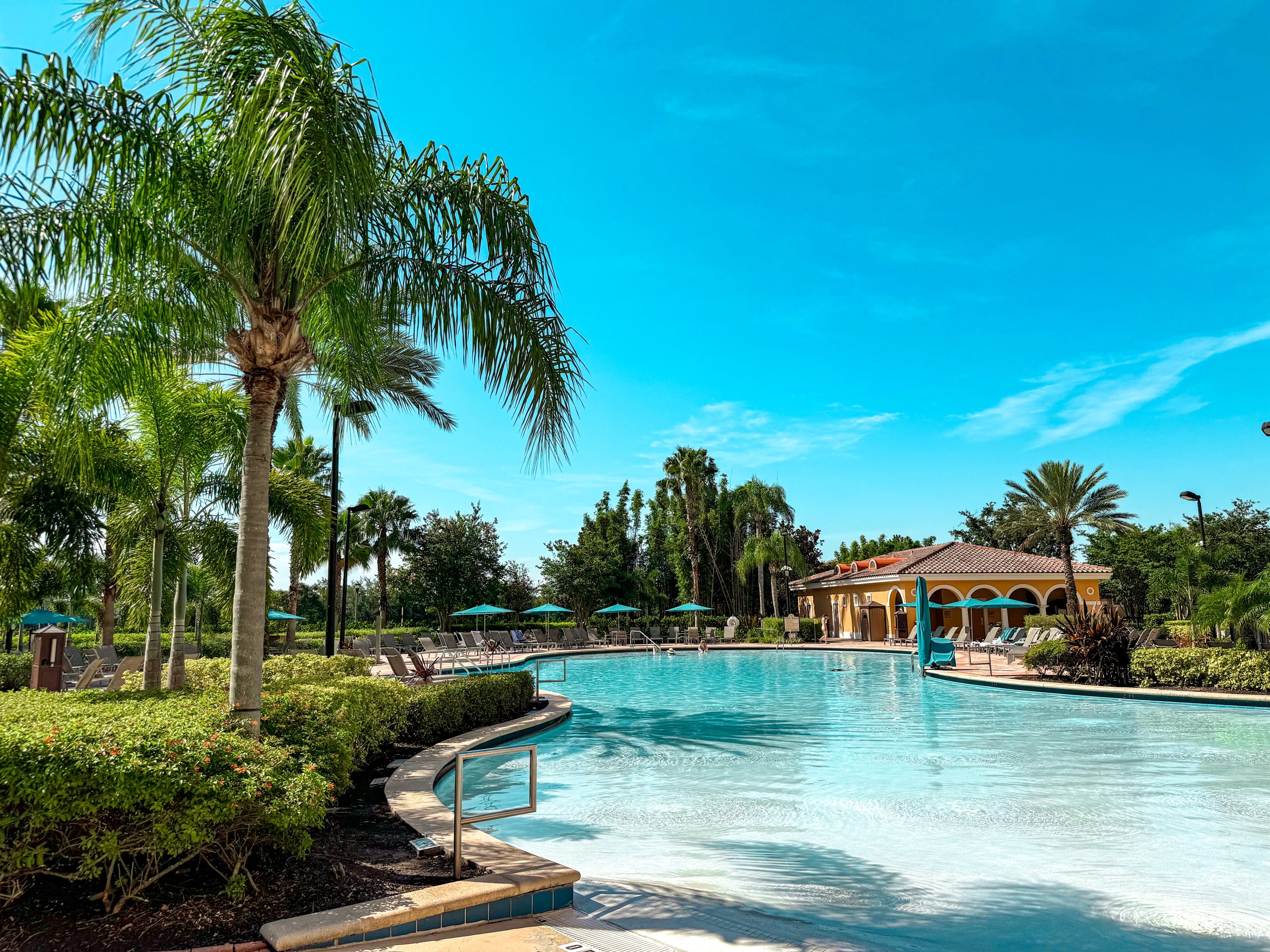 A Perfect Spa Day at Rosen Shingle Creek: What to Expect 5 A curving, crystal blue pool surrounded by bushes and palm trees.