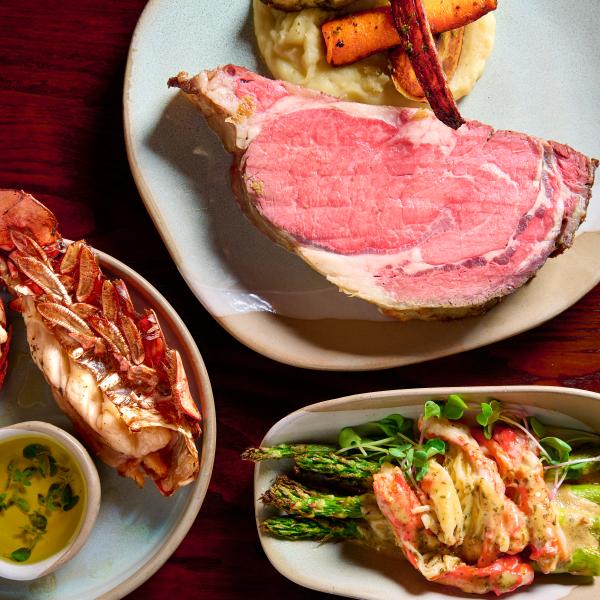The Restaurants at Rosen Shingle Creek: A Different Dinner Every Night 7 An overhead shot of three plates, one with prime rib, one with a lobster tail, and one with asparagus and crab meat at A Land Remembered.