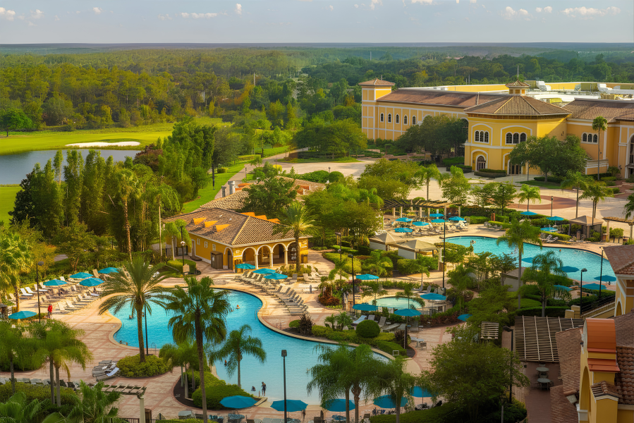 The Restaurants at Rosen Shingle Creek: A Different Dinner Every Night 6 An aerial shot of three of the pools at Rosen Shingle Creek, surrounded by Italian-inspired architecture, palm trees, and a golf course.
