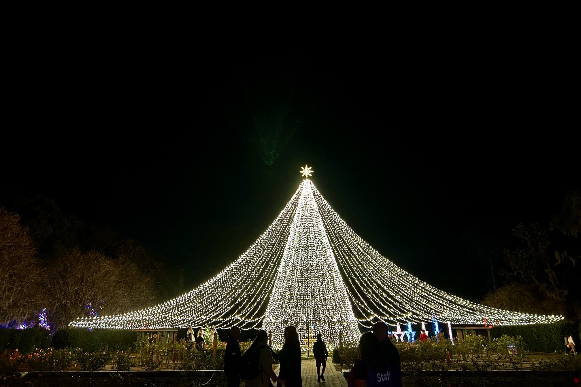 The Ultimate Guide to Orlando Holiday Events 9 A towering glittering white Christmas tree against a dark night sky at Dazzling Nights, a holiday event in Orlando.