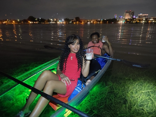A man and woman riding in a glow-in-the-dark kayak at Epic Paddle Adventures in Orlando.