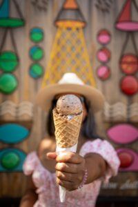 A young woman holds out an ice cream cone, the perfect treat on a hot Orlando day.