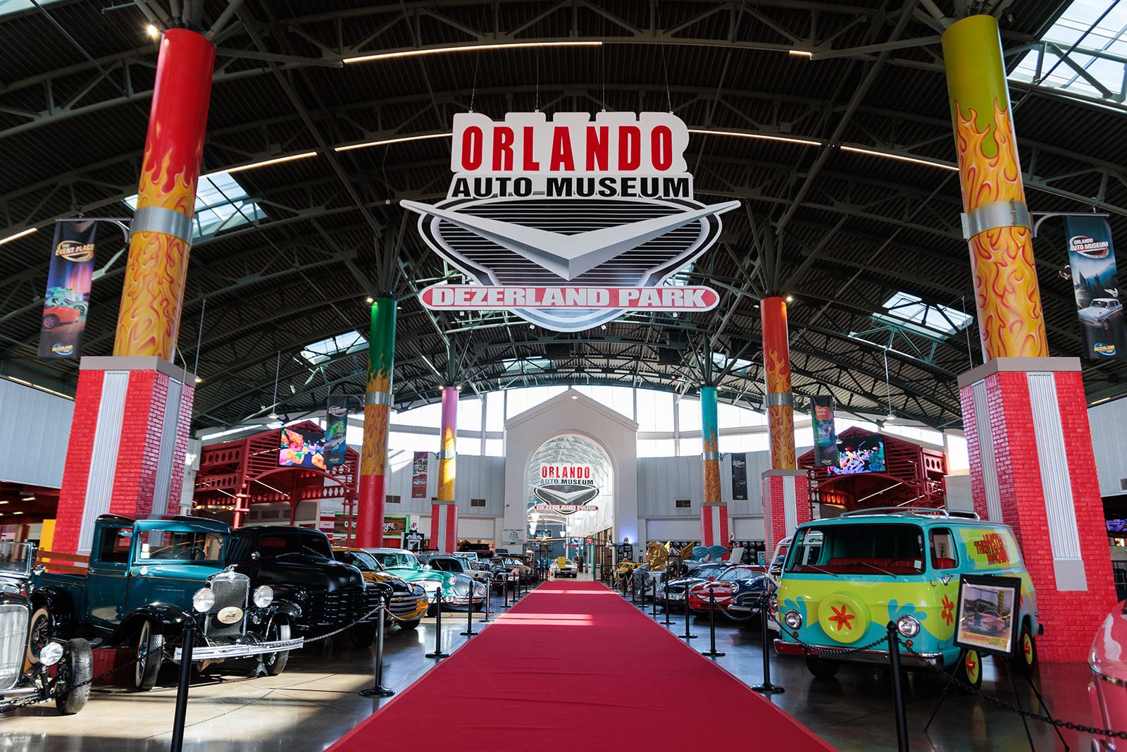Celebrate Dad: 7 Thoughtful Father’s Day Gift Ideas 4 A red carpet beneath a sign reading Orlando Auto Museum Dezerland Park with classic cars lining either side of the aisle.