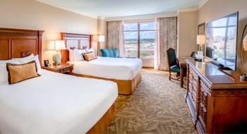 Two queen beds with wooden headboards and white linens in a room with a window overlooking the golf course , Rosen Shingle Creek Double Guestroom