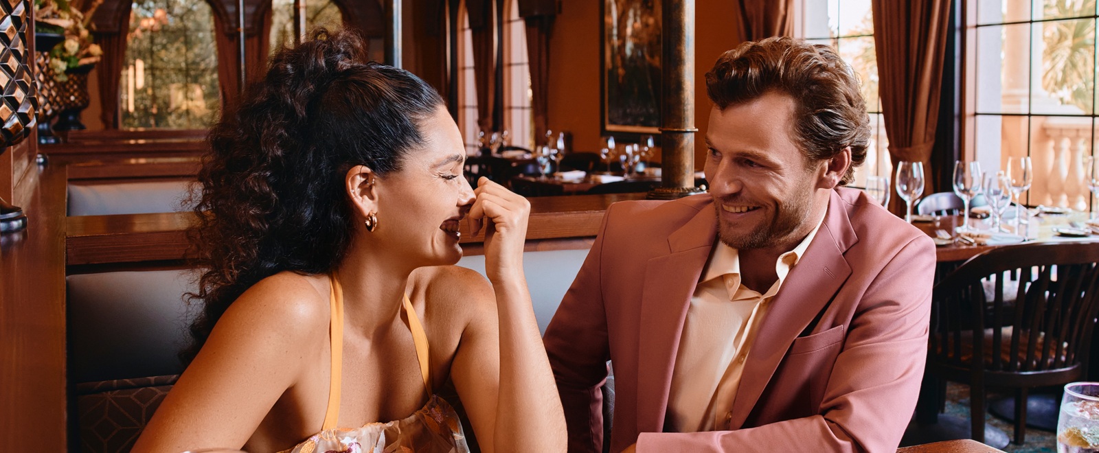 A well-dressed couple sitting at a booth in a restaurant