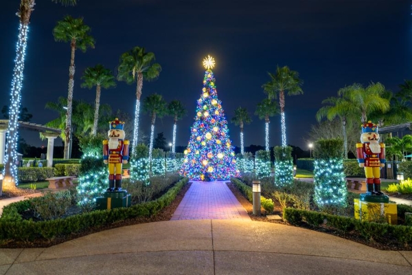 A brightly lit and decorated Christmas tree flanked by rows of lit palm trees and two nutcrackers at Rosen Shingle Creek.