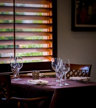 Thanksgiving Without Cooking: Rosen Shingle Creek is a Holiday Escape 3 A neatly set table next to a window with wooden shutters at Cala Bella inside Rosen Shingle Creek.