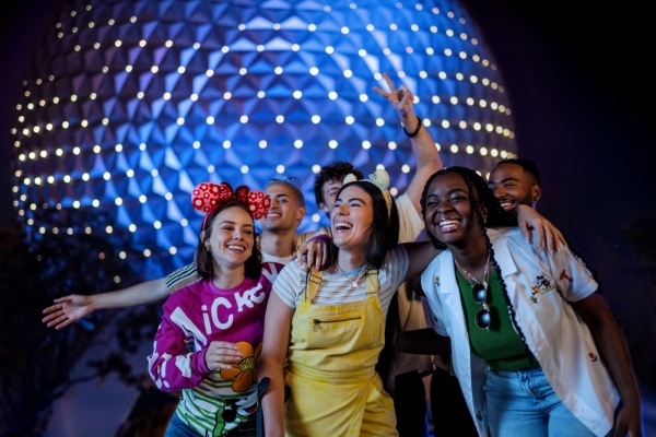 Helpful Tips & Planning Advice for EPCOT's International Food & Wine Festival 5 A group of young people smile and pose in front of Spaceship Earth at EPCOT.