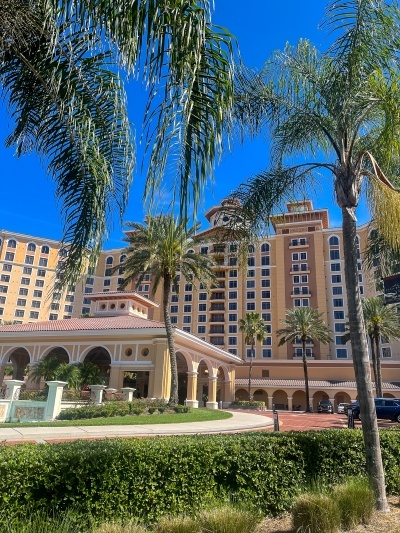 An exterior shot of the entrance of Rosen Shingle Creek with palm trees in the foreground. Stay here while you support local small businesses. 