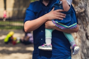 Image of a father holding his infant daughter, a perfect depiction of Father's Day.