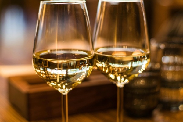 A close-up of two glasses of white wine.