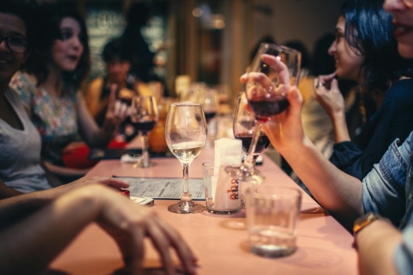 A group of people sat around a table with glasses of wine in mid-conversation. Orlando's best wine bars are all a short drive from Rosen Shingle Creek.